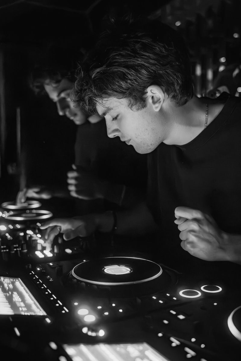 Three DJs at the decks in front of an LED wall.